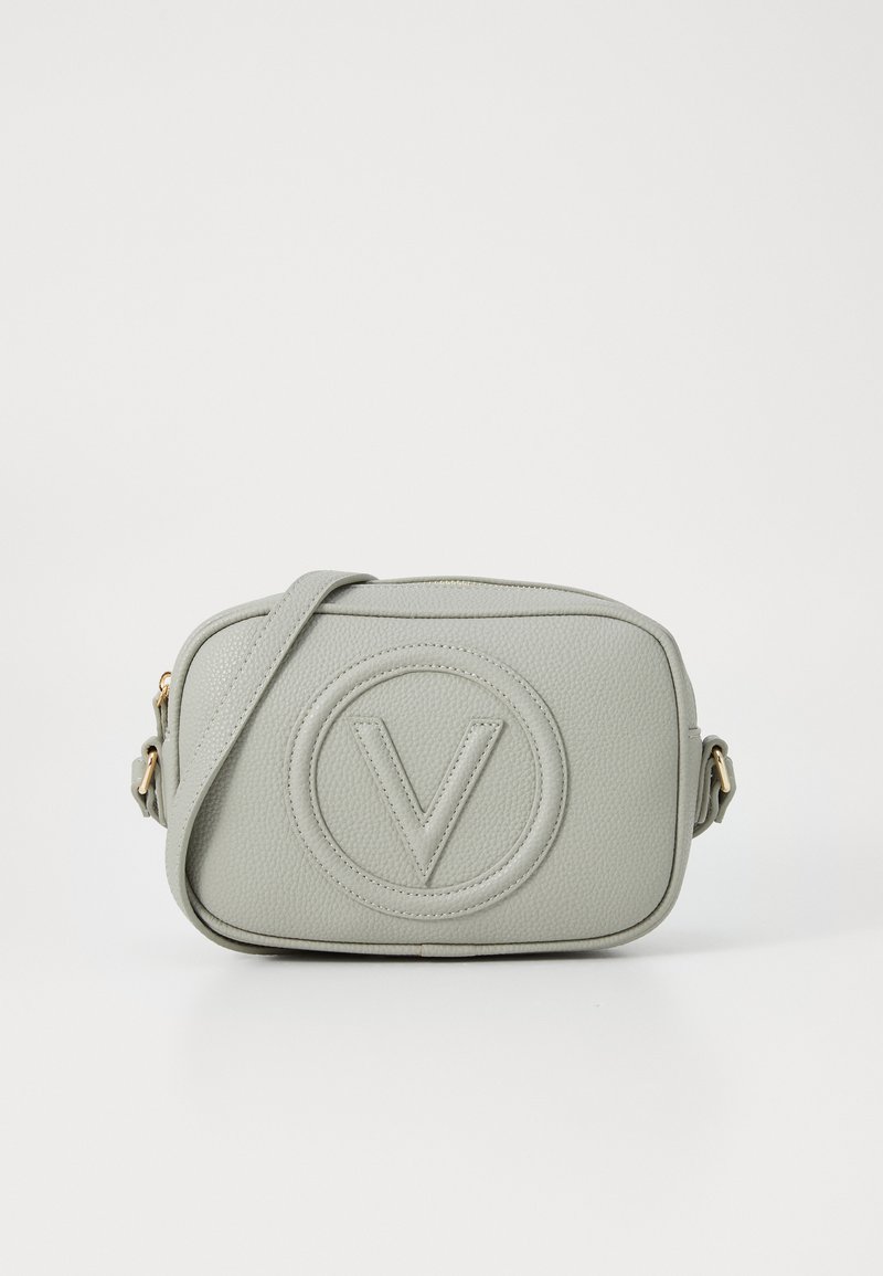 Bolsa crossbody de couro cinza claro com detalhe de logotipo circular em relevo e acabamentos em tom dourado. Forma retangular compacta com alça ajustável.