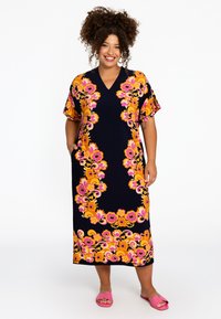 Blumenmuster-Kleid mit navyfarbigem Hintergrund, lebhaften orangen und rosa Blumen, kurzen Ärmeln und seitlichen Taschen. Mittellang, lockere Passform.