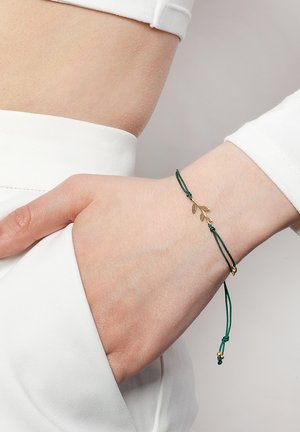 Zielona bransoletka z koralików z akcentami w kolorze złotym, z regulowanym zapięciem i eleganckim, minimalistycznym designem.