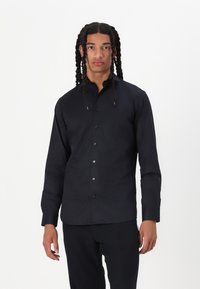 Black long-sleeve shirt made of smooth fabric, featuring a classic collar, button placket, and fitted design. No patterns or accents visible.