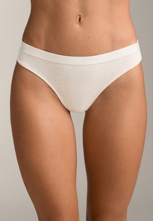 Thong din bumbac în bej deschis, cu un brâu moale și elastic, prezentând un logo „OYSHO” embosat. Textură netedă și design cu acoperire minimă.