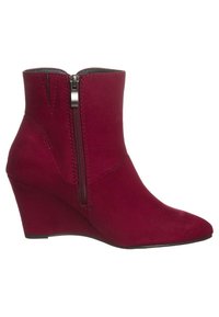 Bottes basses en daim rouge avec un bout pointu et une fermeture éclair latérale. Talon compensé offrant de la hauteur ; texture lisse et coutures nettes.