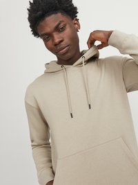 Beige hoodie with a front pocket, adjustable hood, and drawstrings. Features ribbed cuffs and a soft, smooth texture.