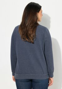 Dunkelblaues Sweatshirt mit langen Ärmeln, ausgefranstem Saum und Ärmeln, weichem Baumwollmaterial, lässiger Schnitt, von hinten gezeigt, mit einfarbigem Muster.