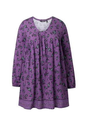 Fialová tunika s dlouhým rukávem s modrým a černým květinovým vzorem, výstřihem do tvaru lodi, záhyby vpředu a ozdobným lemem na spodním okraji.