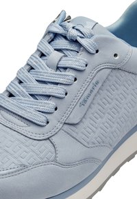 Tennarit vaaleansinisellä värillä, joissa on teksturoitu, kudottu kuosi. Ominaisuuksiin kuuluu litteät nauhat, pyöreä kärki ja pehmustettu pohja. Suora pinta ja ompelutiedot.