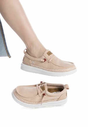 Zapatos casuales de color beige claro con un acento tejido, parte superior de tela suave, cordones elásticos y suela de goma blanca.