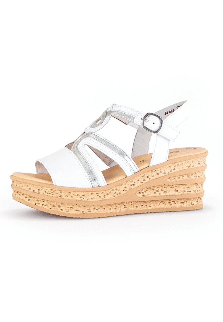 Witte wedge sandalen met uitsnijdingen, metallic accenten en een getextureerde kurken basis. Verstelbare band met een zilveren gesp.