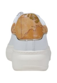 Sneaker bianco con un cappuccio del tallone a motivo mappa marrone. Suola piatta, materiale in pelle liscia e design minimalista che mette in risalto il dettaglio unico del tallone.