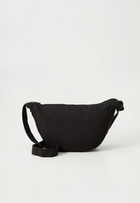 Mala de ombro em nylon preto com forma curva, alça ajustável, fecho de correr e textura suave. Design minimalista sem padrões visíveis.