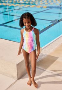 Multicolored one-piece swimsuit featuring a wavy pattern in pink, purple, and blue, with a scoop neck and thin straps, worn by a child.