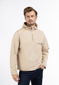 Beige lichtgewicht gewatteerde jas met een half-rits aan de voorkant, voorzien van een borstzak met rits en een gladde, glanzende textuur.
