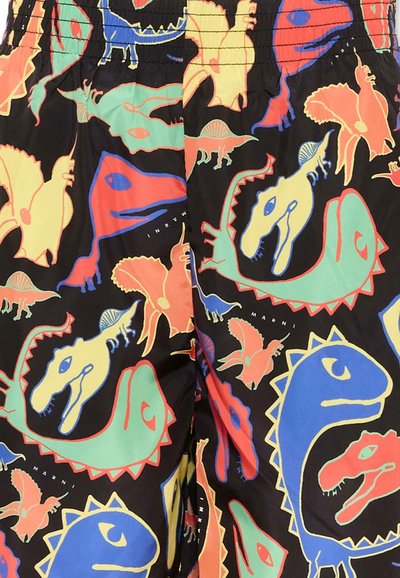 Dinosauri e farfalle colorati in rosso, blu, giallo e verde su tessuto nero con cintura elastica visibile.