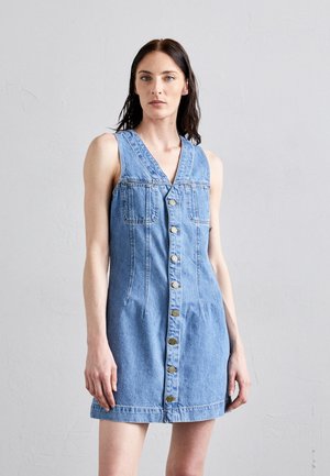Vestido de mezclilla en azul claro, sin mangas, con un escote en V profundo, cierre frontal de botones, dos bolsillos en el pecho y una cintura ajustada para una silueta acampanada.