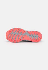 Semelle de chaussure de course avec une base grise et une bande de roulement en caoutchouc corail vif en motif ondulé et segmenté pour l’adhérence et la flexibilité.