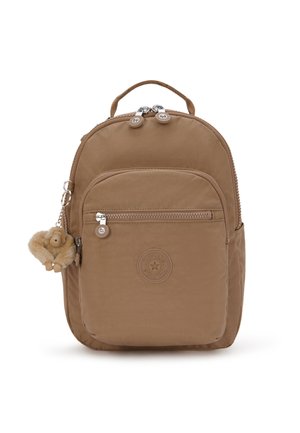 Brown nylon backpack with a rounded shape, two zippers, front pocket, and a plush monkey keychain detail. Features a logo badge on the front.