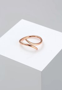 Rosenvergoldeter Ring mit einem eleganten, sich drehenden Design. Glatte Textur mit einer minimalistischen, offenen Form. Abgerundete Kanten und eine polierte Oberfläche.