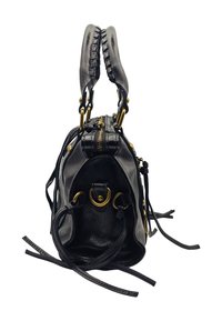 Sac à main en cuir noir avec des poignées tressées, des accents en métal doré et des franges latérales. Il comporte un dessus zippé et des anneaux circulaires distincts.
