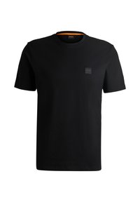 Svart bomull t-shirt med rund hals och korta ärmar. Har en liten fyrkantig logotypapplikation i övre vänstra hörnet.