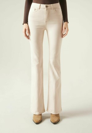 Beige flared jeans med høj talje, lavet af denim. Har forlommer, en enkelt knaplukning og en glat, tekstureret overflade.
