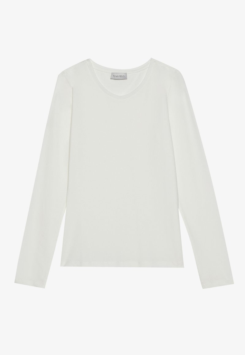Top bianco a maniche lunghe realizzato in tessuto morbido con scollatura rotonda e design semplice. Texture liscia, senza motivi o accenti.