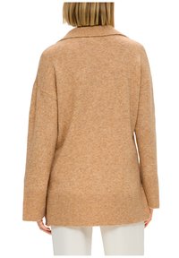 Maglione sopra misura, di colore marrone chiaro, realizzato in tessuto morbido. Presenta un colletto, spalle cadenti e polsini e orlo a coste. Aspetto testurizzato.