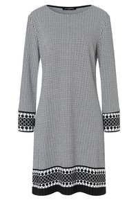 Schwarz-weiß gemustertes Kleid mit langen Ärmeln, rundem Hals, strukturierter Oberfläche und einem auffälligen geometrischen Saumdesign.