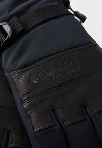 Mustast nahast ja tumesinistest kangast kindad, millel on reguleeritavad rihmad ja kuuldus Columbia Titanium logo. Palmialal on tekstureeritud haardepind.