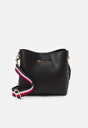 Schwarze Leder-Bucketbag mit goldfarbenem Logo, abnehmbarem Schulterriemen in Marineblau mit rot-weiß gestreift und goldfarbenen Beschlägen.