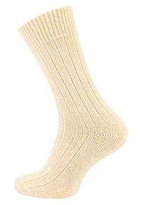 Calza di cotone beige a coste con una consistenza morbida, caratterizzata da un polsino rilassato e un'area delle dita liscia, progettata per il comfort e l'uso quotidiano.