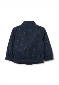 Chaqueta bomber azul marino con un patrón sutil, puños y dobladillo elastizados, y un cuello clásico. Fabricada con material ligero y resistente al agua.