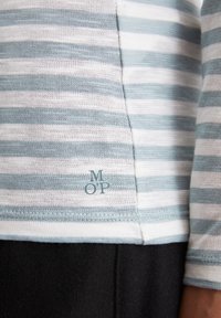 Stripet langermet topp med alternerende lyseblå og hvite striper, med en liten "MOP" logo aksent nederst til venstre.
