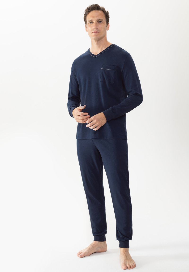 Ensemble de pyjama bleu marine en tissu doux, comprenant un haut à manches longues en v avec une poche poitrine et un pantalon fuselé assorti avec des poignets élastiques.