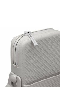 Custodia rigida grigia con superficie testurizzata, caratterizzata da motivi circolari in rilievo. Include una cerniera con etichetta e un angolo arrotondato con ferramenta.