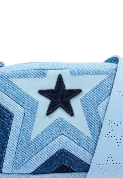 Tissu en denim avec des motifs d'étoiles superposés dans des nuances de bleu et une sangle bleu clair avec des motifs d'étoiles perforées.