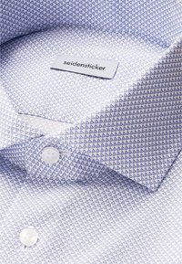 Camicia bianca con bottoni, caratterizzata da un motivo triangolare blu, tessuto liscio, colletto standard e etichetta Seidensticker all'interno.