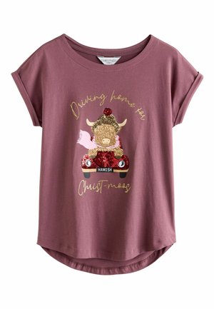 Short-sleeved mauve t-shirt made of soft fabric, featuring a glittery graphic of a cow in a car with the text "Driving home for Christ-moos."