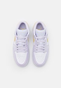 Paire de baskets blanches et violet clair avec des embouts perforés, des lacets et des accents dorés, vues de dessus sur un fond blanc.
