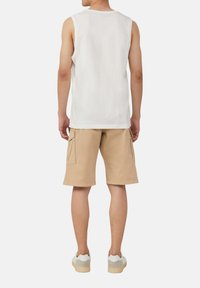Weißes Baumwoll-Tanktops, beige Cargo-Shorts mit seitlichen Taschen und grau/weiße Sneakers. Einfacher, lässiger Schnitt ohne auffällige Muster.