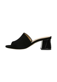 Mule en suède noir à bout ouvert avec un talon bloc noir géométrique et une semelle intérieure beige lisse. Design épuré et minimaliste avec une texture douce.