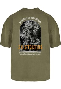 Olivengrøn bomulds t-shirt med et sort og hvidt grafisk tryk på ryggen, med udsmykket tekst og religiøse motiver i et buet design.