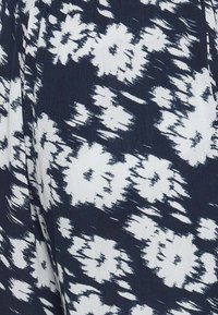 Tissu bleu marine avec un motif floral blanc. La texture semble légèrement froissée avec une finition douce et tissée.