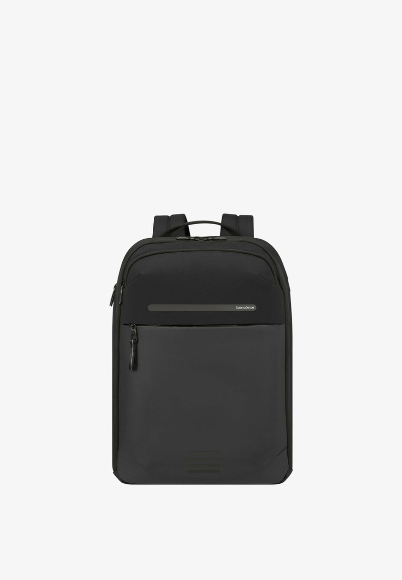 Zaino nero con una texture liscia e opaca. Presenta cerniere doppie, una tasca frontale con zip e spallacci imbottiti. Design minimalista.