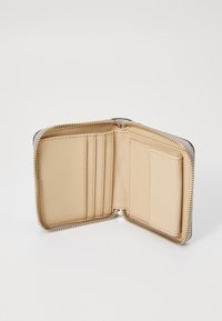 Beige lommebok med glidelås; innsiden inkluderer kortlommer og en glatt tekstur. Sølvfarget hardware detaljer forbedrer designet.