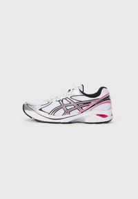 Scarpa sportiva bianca con accenti neri e rosa, tomaia in mesh, colletto imbottito e suola strutturata per la presa. Presenta dettagli riflettenti.