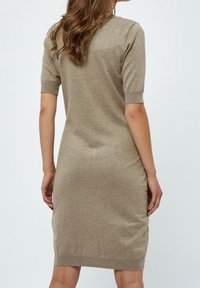 Robe tricotée beige avec manches courtes, silhouette ajustée et ourlet côtelé. Texture uni, longueur aux genoux, légère taille marquée. Vue de dos affichée.