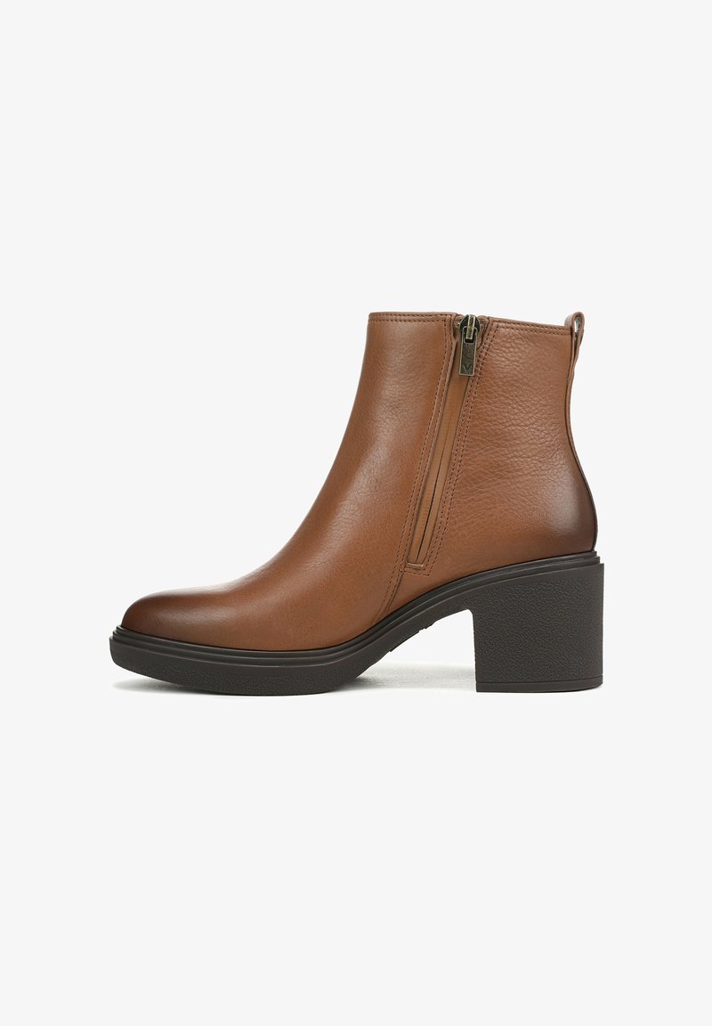 Bruine leren enkellaars met een ronde neus, zijrits en een zwarte blokhak met textuur. Gladde oppervlakte en minimale details.