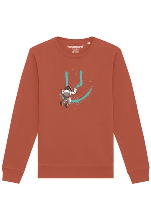 Sweat-shirt couleur rouille avec un graphique d'astronaute et des éclaboussures de peinture turquoise. Manches longues, col ras du cou et texture de tissu douce.