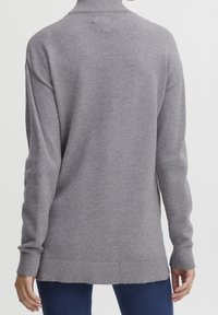 Maglione grigio chiaro lavorato a maglia con collo alto, maniche lunghe, polsini e orlo a coste. Texture morbida e vestibilità rilassata per il massimo comfort.