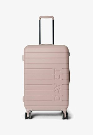 Valise rigide rose avec des rainures horizontales, poignée noire extensible, double roues et une poignée latérale. Présente un logo en relief.